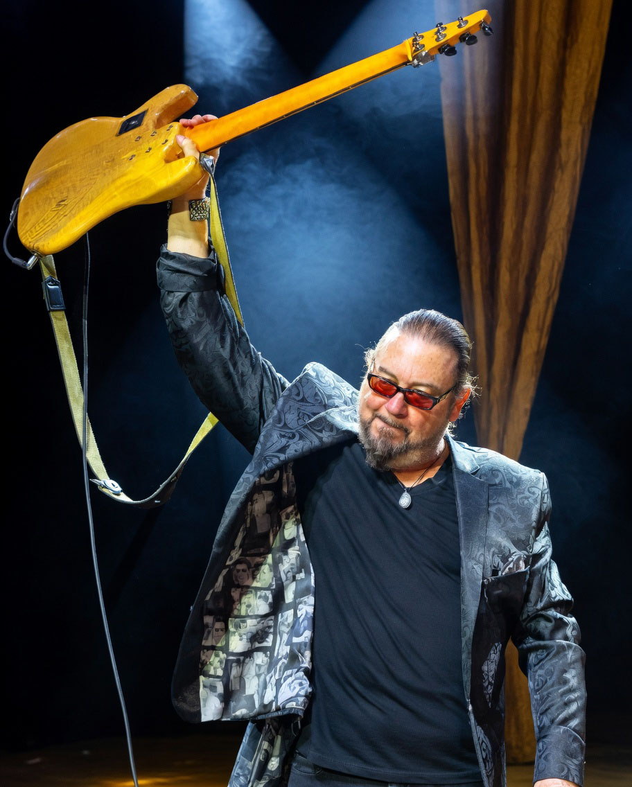 Kenny Lee Lewis raising his bass on stage